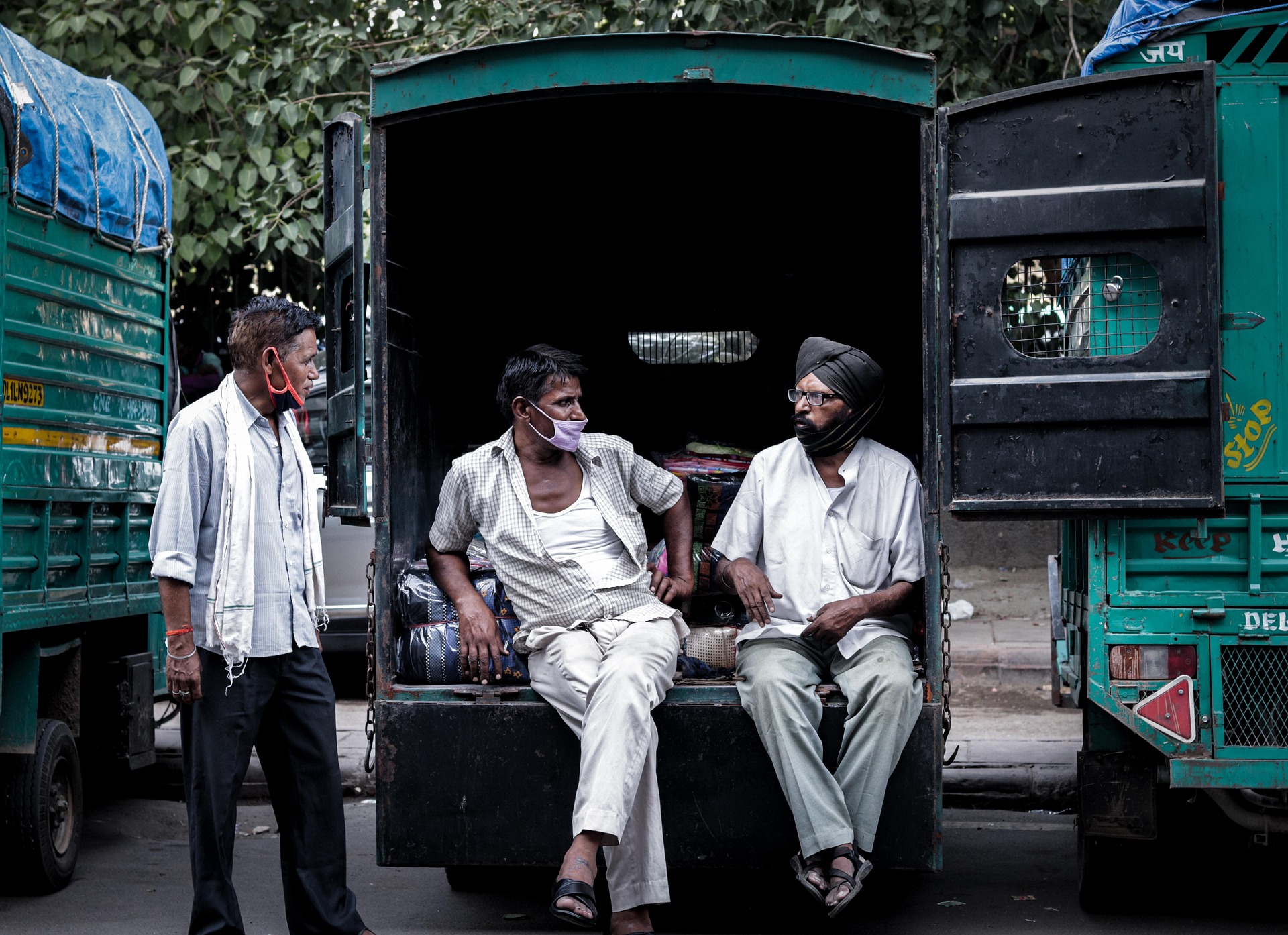 Three men resting in the back of a truck during a work break