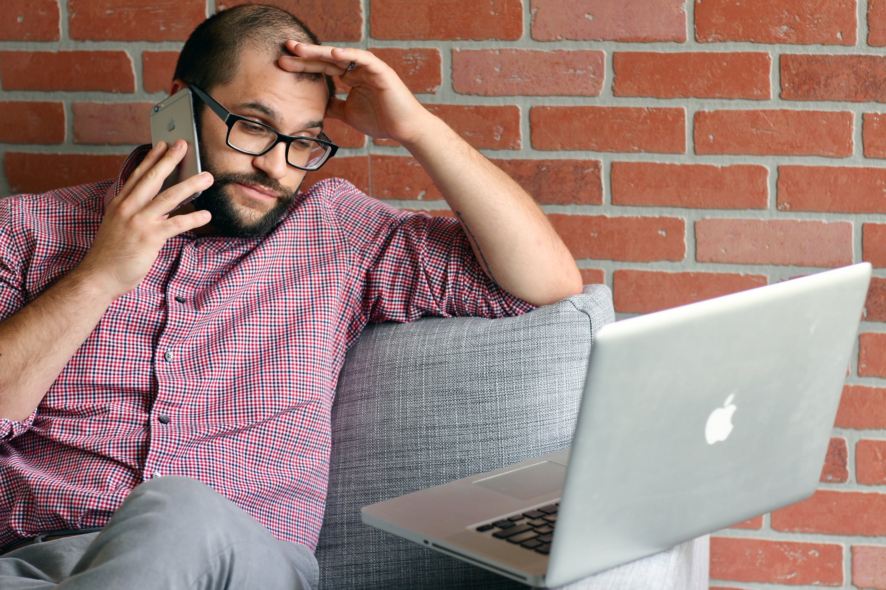 A person looking stressed while taking an unexpected phone call