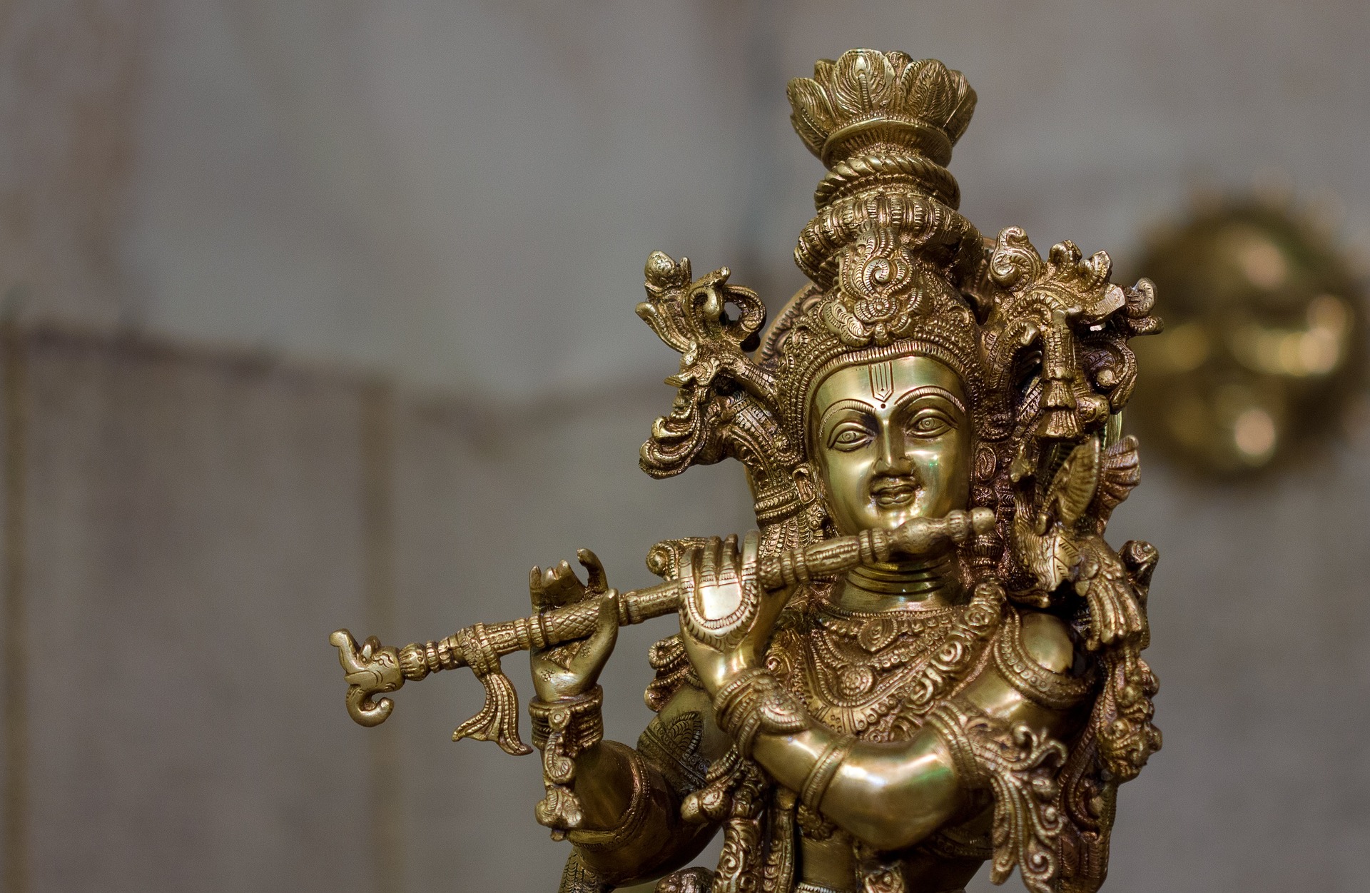 A brass statue of the Hindu god Krishna playing a flute
