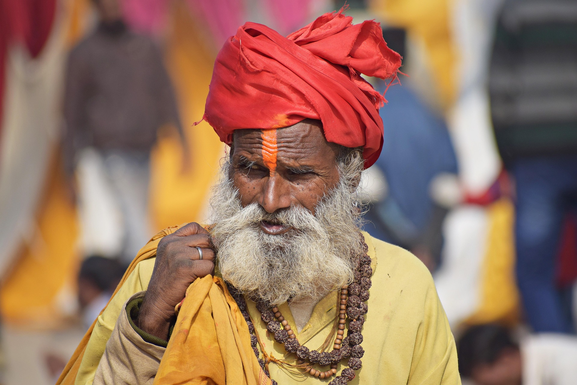 An elderly sadhu (Hindu holy man) in a saffron robe and red turban